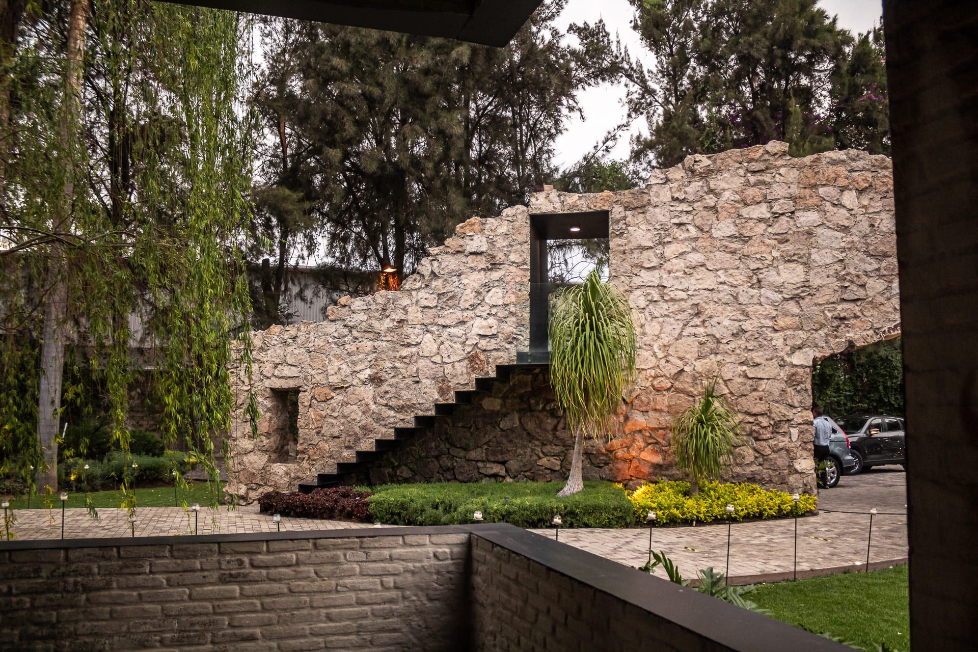 Escalera y muro de piedra junto a los jardines, con luz cálida